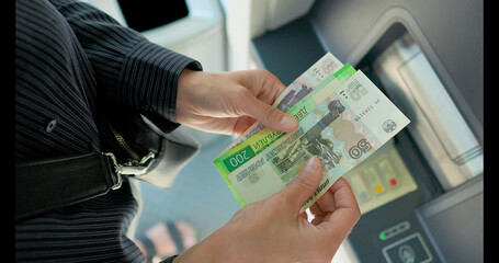 Business woman counting russian ruble near ATM machine 
