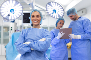 Portrait of happy woman surgeon standing in operating room, ready to work on a patient. Female...