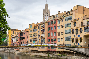 Girona, Spain - May 13th, 2023: TEMPS DE FLORS - Flower Time. Princess bridge with views of the Cathedral and the colorful houses of Onyar river on a rainy day. Banner 