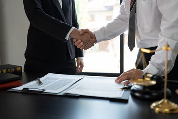 Lawyer standing handshake with businessman to sign partnership agreement, business contract partner handshake concept.