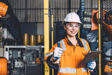 Engineer woman thumbs up  working safety in modern automation factory happy smiling