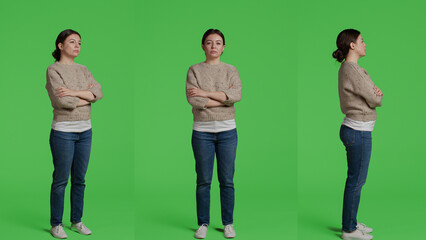 Obraz premium Caucasian woman standing over full body green screen backdrop, posing in front of camera. Girl model feeling confident and joyful sitting on greenscreen background in studio, casual look.