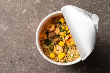 Instant cup noodles filled with dried shrimp and meat toppings