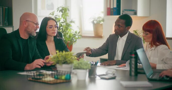 Corporate employees during meeting in office discussing topics related to sales