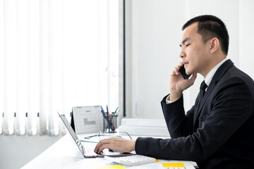 Fototapeta premium Smart businessman’s sitting in the office room and using mobile phone.