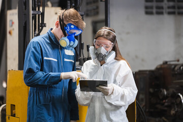 Team inspector wearing chemical protective mask and hazmat suit examining chemistry in industrial....