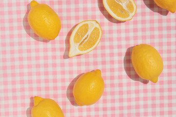 Summer creative layout with lemons on pastel pink plaid  background. 80s or 90s retro aesthetic...