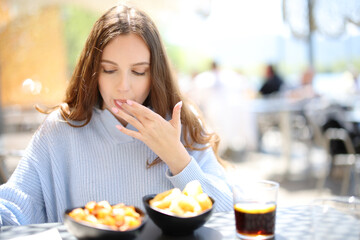 Restaurant customer eating and licking finger