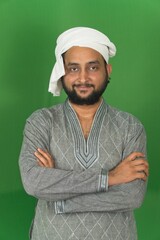 Young Indian farmer standing arms crossed, smiling and looking at camera, isolated on green background, green screen