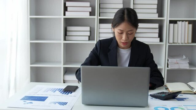 Confident businesswoman using calculator and laptop to calculate finance, tax, accounting, statistics and analytical research concept.
