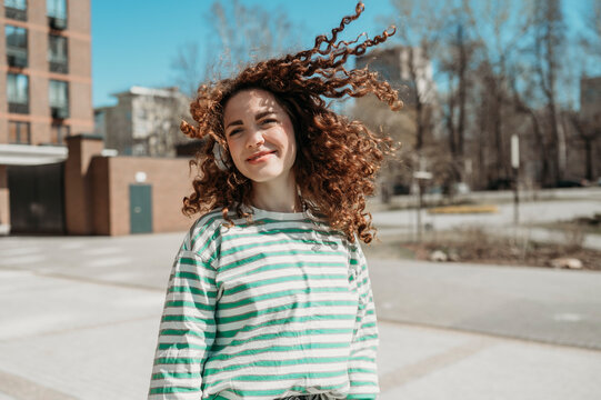 Smiling woman with tousled hair at sunny day