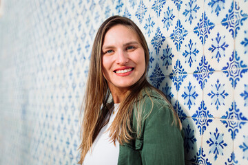 Happy woman near patterned tiled wall