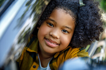 Smiling girl with curly hair in car