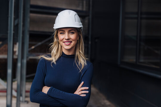 Confident businesswoman with arms crossed in factory