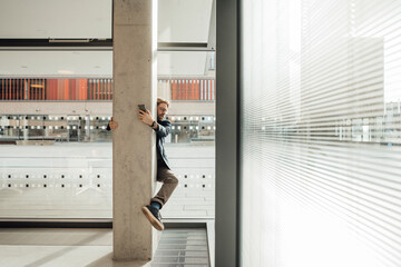 Businessman embracing column in building