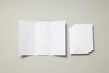 Blank white sheet and envelopes on light gray background