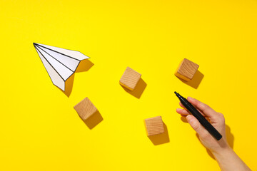 Business, startup and sponsorship concept with paper plane on yellow background