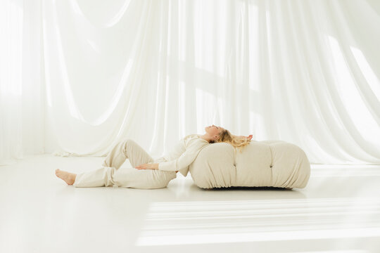 Woman relaxing on cushion by translucent couch