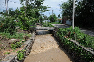Water flows down a rusty branch into the bed of a mountain river.