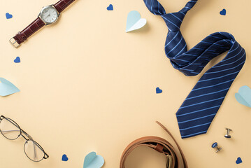 Fashionable Father's Day arrangement. Top-down view of necktie, watch, accessories, belt, spectacles, hearts on beige background with a blank frame for text or advertisement