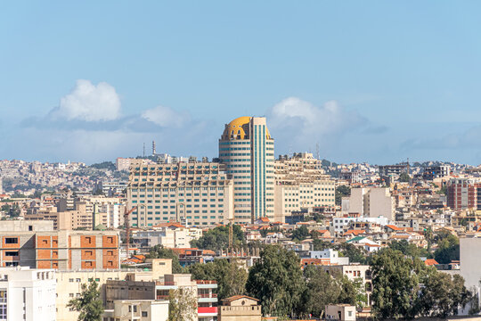 El Qods shopping and business center building outdoor facade. Aerial view with it's rounded tower and  yellow dome. Trees, buildings and blue sky with clouds