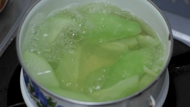 Chayote squash is blanched in a small pot of boiling water for dessert