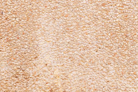 Abstract Background or texture of pebbles small or gravel color yellow, orange attached with beautiful cement concrete. Natural pattern used to make wallpaper website along walls of houses, building.