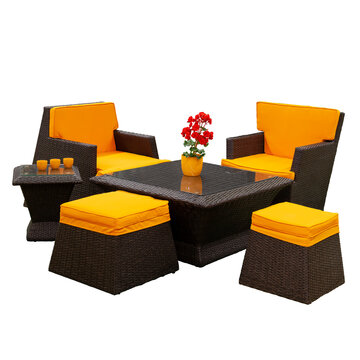 Garden set of rattan furniture with orange pillows and some decoration isolated on white with a clipping path.
