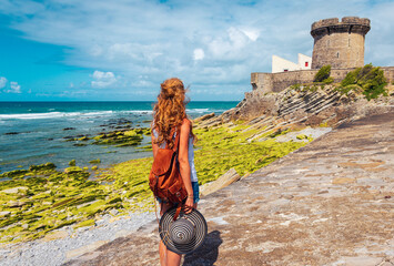 French woman admiring Socoa Fort in Ciboure- Saint Jean de Luz- tourism in France,  Basque country, Nouvelle aquitaine - obrazy, fototapety, plakaty
