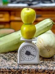 Two apples on an antique scale in a kitchen. Healthy food and nutrition concept.