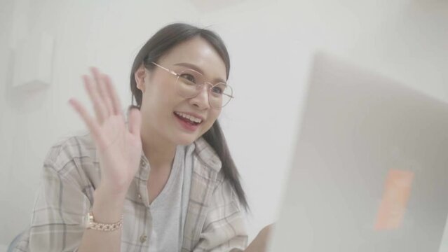 Asian freelance business woman using laptop 
 video call  freind in bed at home.