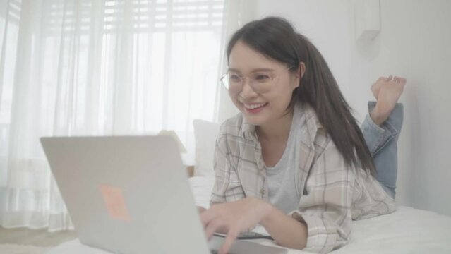Asian freelance business woman using laptop 
 video call  freind in bed at home.