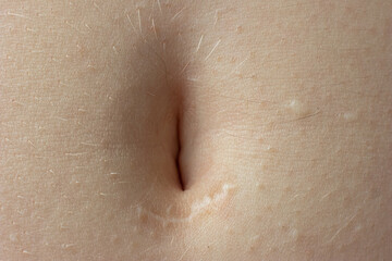 Young woman's belly button. Macro close up shot, unrecognizable person - obrazy, fototapety, plakaty