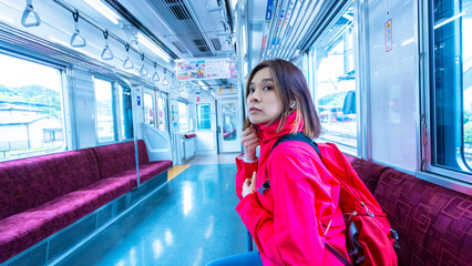 woman wear a windbreaker and on board in japanese train in countryside