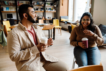 Laughing multiethnic colleagues chefs work in kitchen of cafe