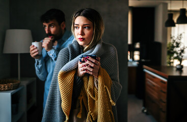 Freezing man and woman suffering from cold or flu fever or having trouble with central heating - obrazy, fototapety, plakaty
