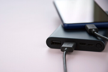 Power bank for charging mobile devices. Black smart phone charger with power bank.