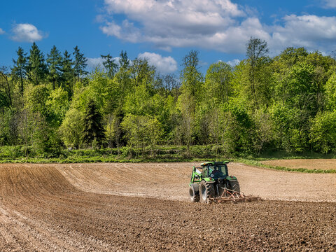 Farm tractor harrowing arable field