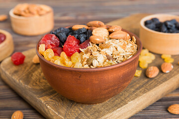 Cooking a wholesome breakfast. Granola with Various dried fruits and nuts in a bowl. The concept of a healthy dessert. Flat lay, top view with copy space