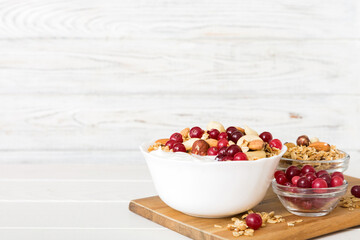 Healthy breakfast food with granola, yogurt, fruits and nuts. Dessert parfait with dried fruits for breakfast
