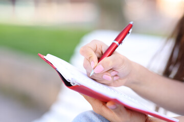 Close up of a hand wrting in agenda in the street