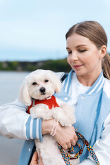 Blonde woman holding maltese dog