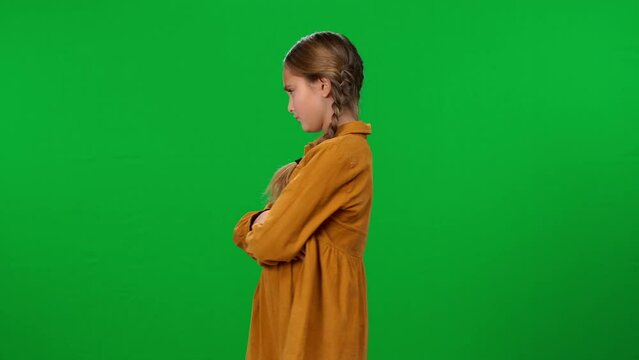 Pretty dissatisfied teen girl shaking hand turning away on green screen background. Cute unsatisfied Caucasian stubborn teenager posing misbehaving on chroma key
