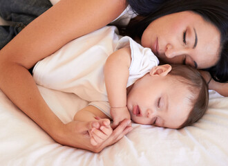 Baby, sleeping and mother holding hands on bed with parent support, care and love. Relax, home and child sleep with mom in a house feeling tired and sleepy with mama rest with kid dreaming together
