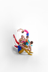 Young girls, ballet dancer in bright tights and bodysuits dancing, training against grey studio background. Concept of beauty, creativity, classic dance style, elegance, contemporary art