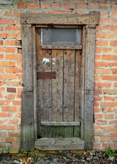 Dilapidated wooden door in a brick building