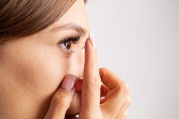 Woman holds contact lens on her finger, eye care and the choice between the means to improve vision.