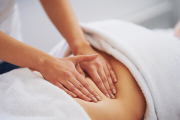 Fototapeta na wymiar Woman having a belly massage in salon