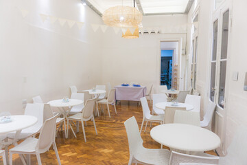 Room full of white chairs and tables for a celebration