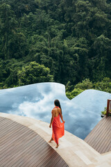 Woman near poolside of holiday resort - obrazy, fototapety, plakaty
